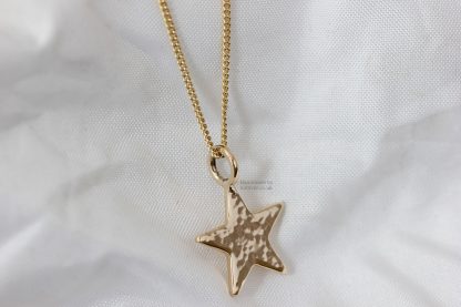 Side view of glitter hammered 9ct yellow gold star pendant