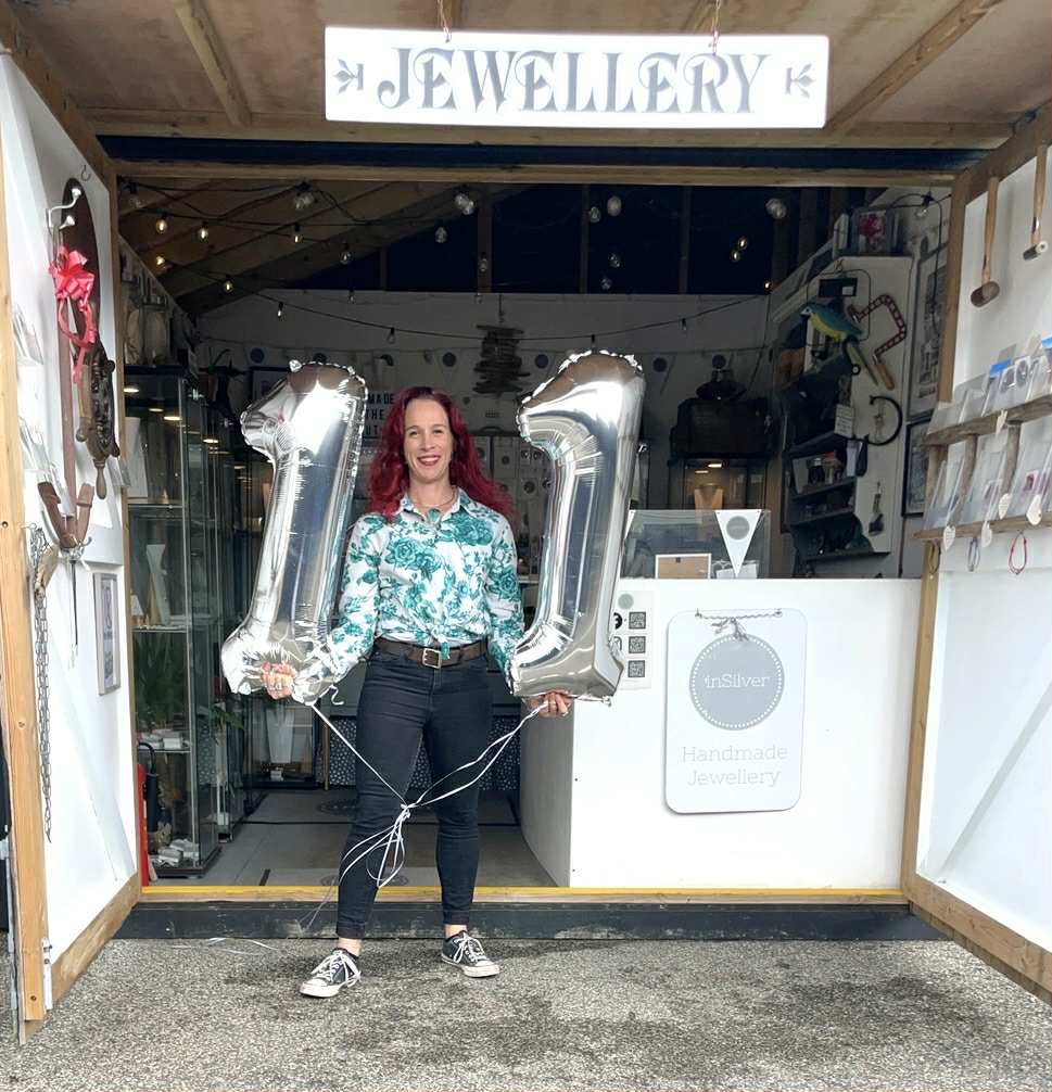 Aimi standing in the entrance to the hut, holding number 11 balloons.